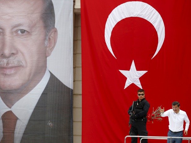 Il Primo ministro turco Ahmet Davutoglu lancia dei fiori sulla folla durante una manifestazione elettorale del giugno 2015 / credits: Murad Sezer - Reuters