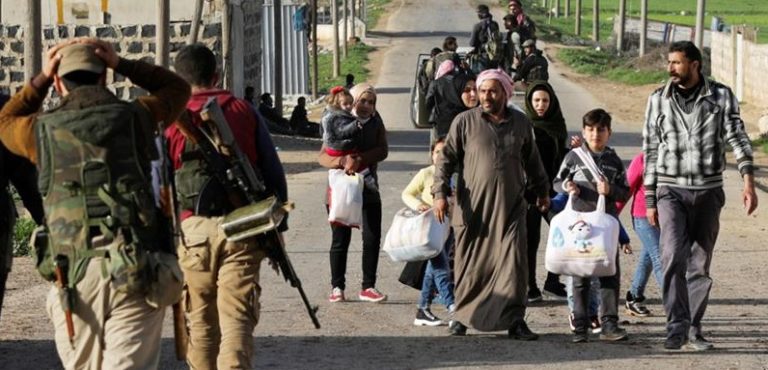 Civili di Afrin incrociano dei ribelli siriani che si dirigono in città. Credits to: Khalil Ashawi/Reuters.