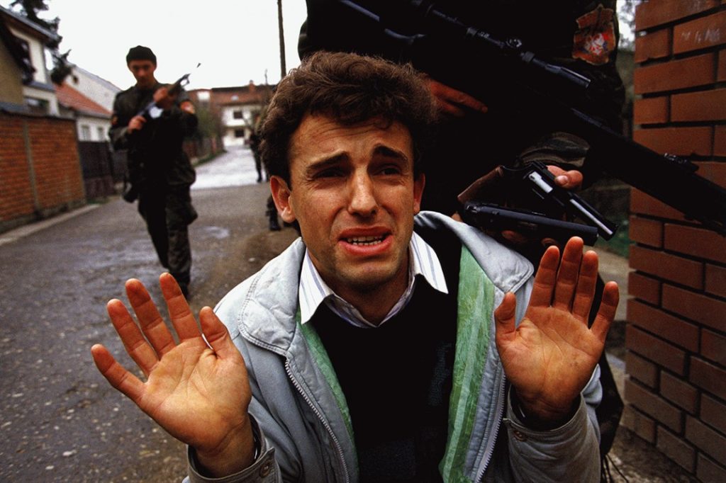 Un mussulmano a Bijelina, Bosnia prega per la sua vita, dopo essere stato catturato dalle Tigri di Arkan nella primavera del 1992 (il gruppo delle Tigri fu tra i principali esecutori della pulizia etnica attuata dai Serbi nei primi sei messi del conflitto Bosniaco) © Ron Haviv