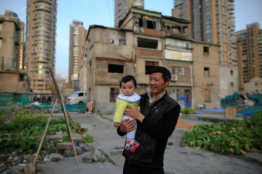 Yueyue è tenuta in braccio da suo nonno davanti alla loro casa nel quartiere di Guangfuli – Aprile 2016 © Aly Song