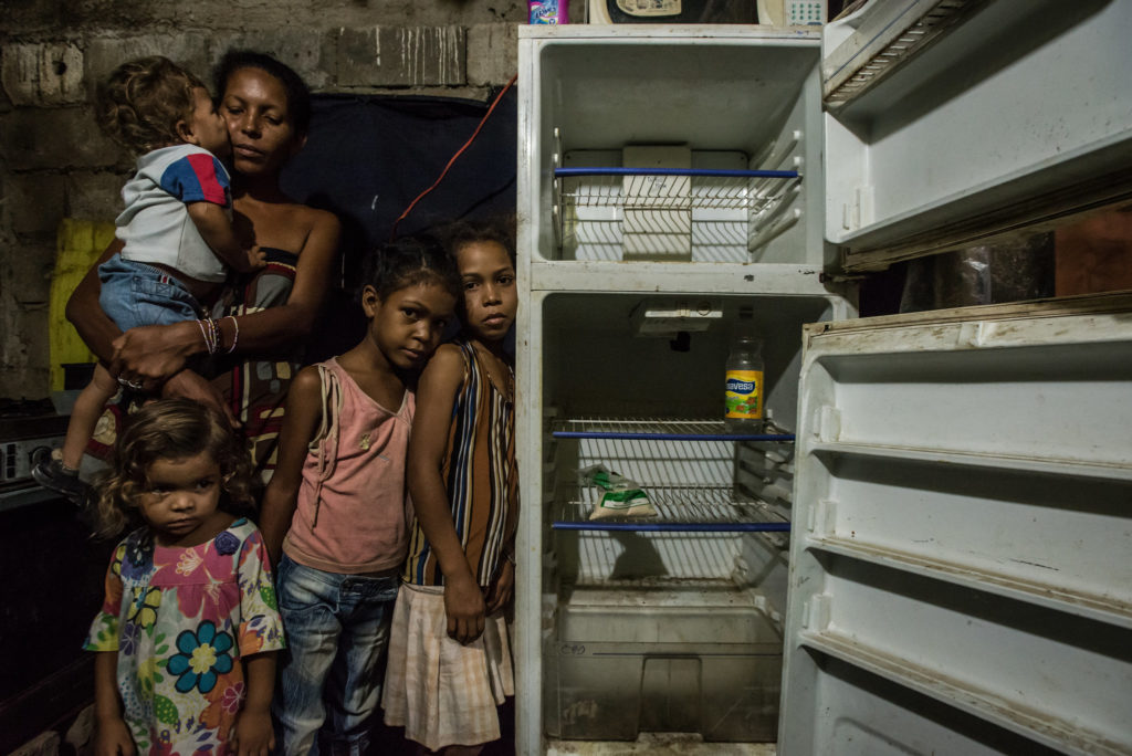 Leidy Cordova, 37, con quattro dei suoi cinque figli, nella loro casa a Cumanà, Venezuela. Il loro frigorifero rotto contiene il solo cibo nella casa: un sacchetto di farina di mais e una bottiglia di aceto. © Meridith Kohut