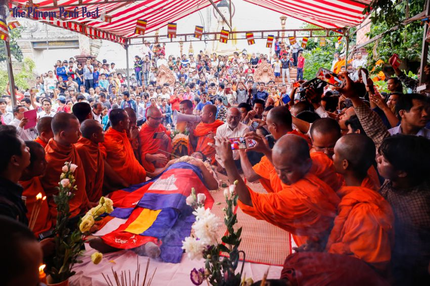 Monaci buddisti pregano intorno alla salma dell'attivista politico Kem Ley durante i suoi funerali. Credits: Pha Lina