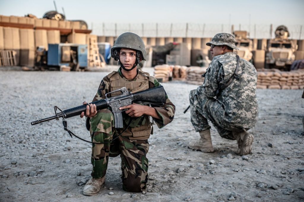 Siamo a Lakokhel nella provincia di Kandahar, dove un soldato americano addestra un adolescente afghano arruolato tra le fila dell'esercito regolare. 2015 Credits to: Ben Brody/The GroundTruth Project