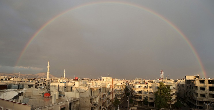 Un arcobaleno sovrasta Douma, sobborgo di Damasco, dopo un attacco aereo dell'aviazione siriana sul principale ospedale da campo della cittadina il 29 Ottobre 2015. Credit to: REUTERS/Bassam Khabieh.
