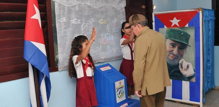 Il presidente cubano Raul Castro vota durante le elezioni municipali a fianco dell'immagine del defunto presidente e fratello Fidel Castro a L'Avana, Cuba, il 26 novembre 2017. Credits to: Estudios Revolucion, via REUTERS.