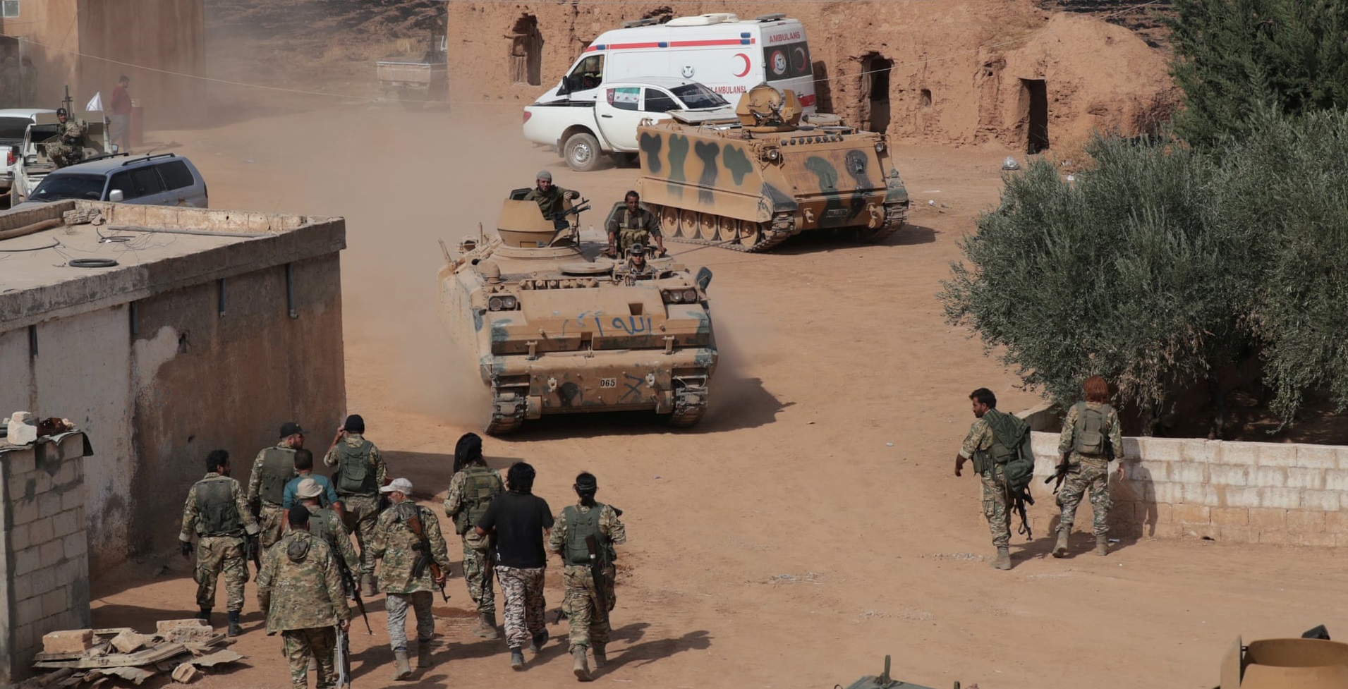 Milizie siriane appoggiate dalla Turchia guidano i carri armati vicino alla città di confine di Tal Abyad. Credits to: Khalil Ashawi/Reuters.